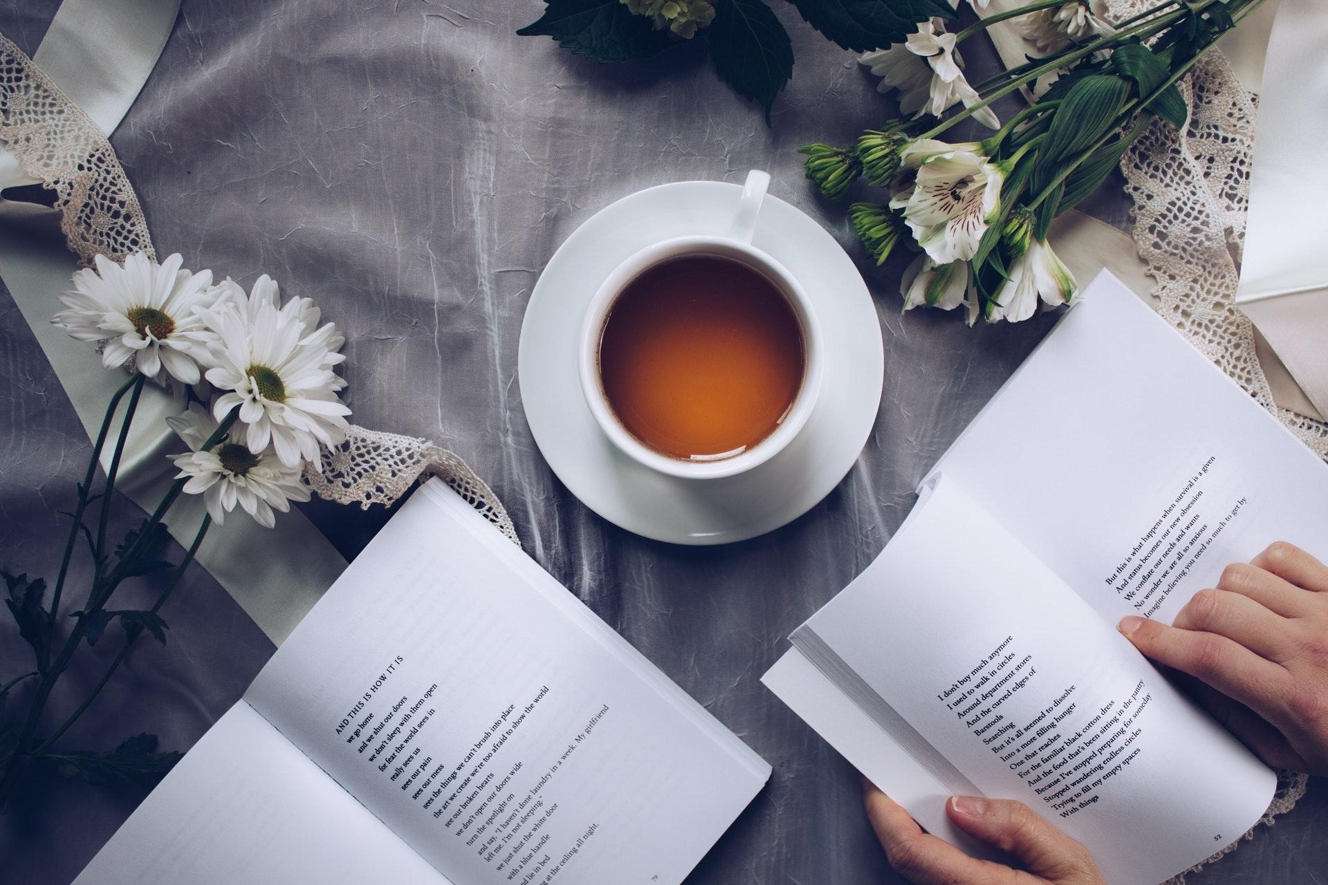 Tips to help calm the body and mind - a person reads a book with tea