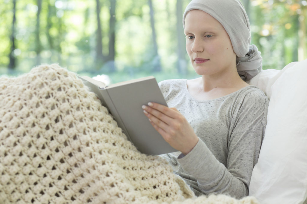 Cancer patient reading a book in hospice care.